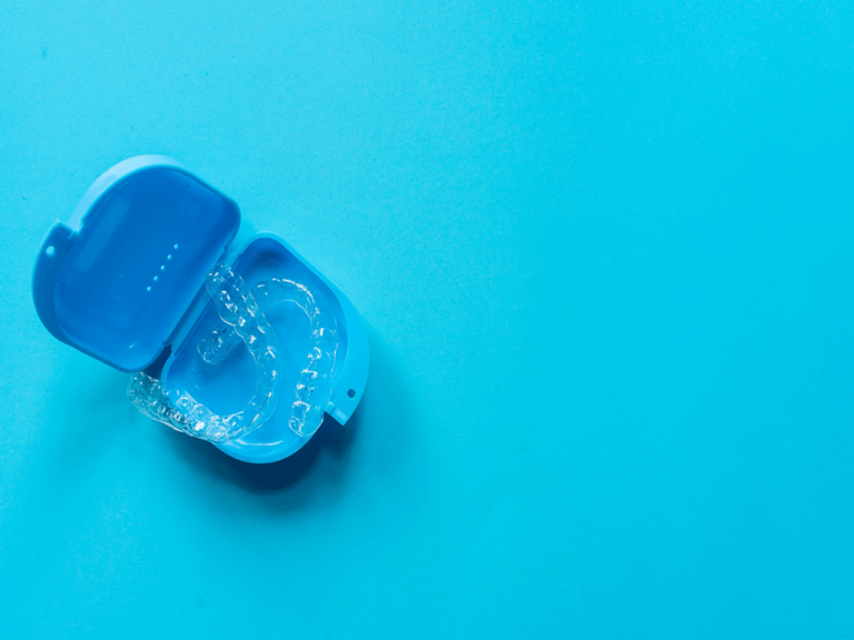 Image of clear aligners in a blue case on a blue background