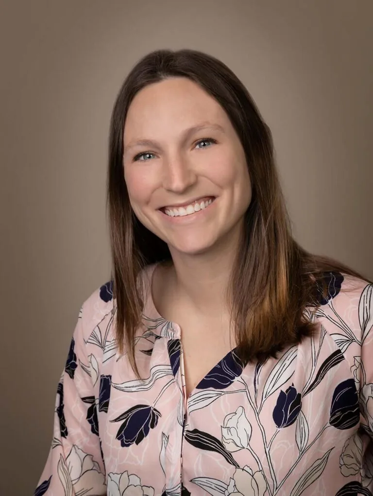 Dr. Casey Burns of Willow Dental in New Berlin, WI. The image shows a person wearing a light pink blouse with a floral pattern. The blouse features large flowers in shades of black, white, and dark blue.